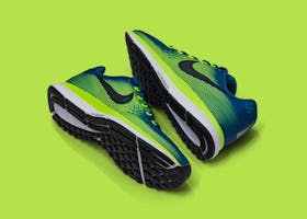 From above of colored sneakers with blue and green surface and green and white and black sole for comfortable moving around streets against green background